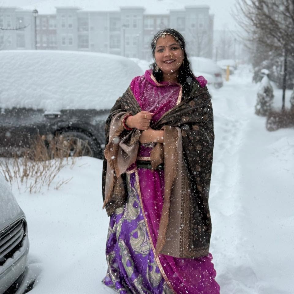 Disha Naresh Gaur standing outdoors in the snow wearing a colorful traditional outfit